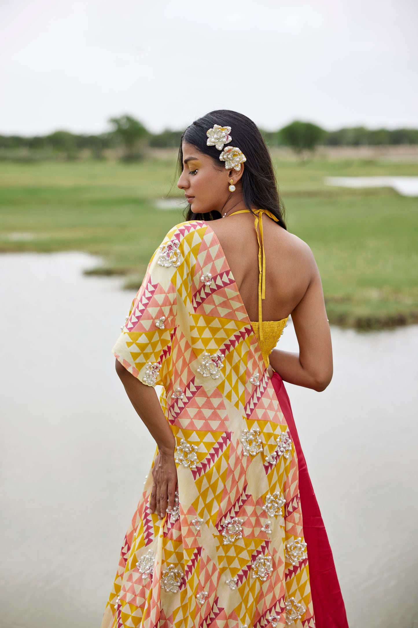 Yellow lehenga set with a patched hand-block border and a side tie detail on a highlighted cape for women