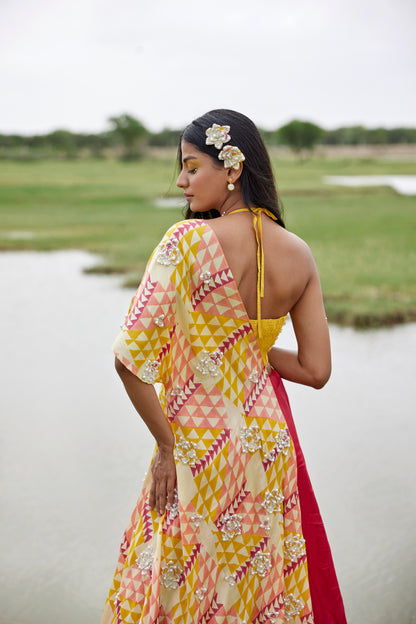 Yellow lehenga set with a patched hand-block border and a side tie detail on a highlighted cape for women