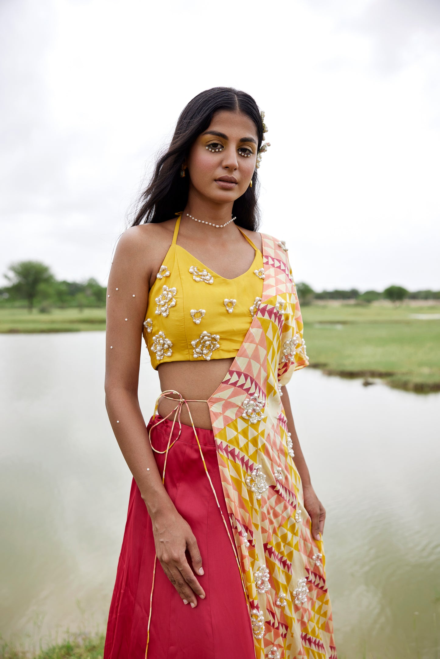 Yellow lehenga set with a patched hand-block border and a side tie detail on a highlighted cape for women